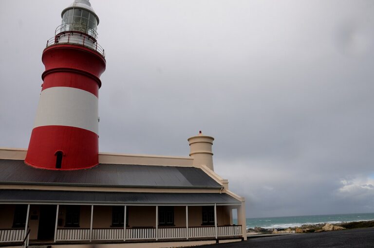 Red-and-white Cape Agulhas Lighthouse beneath cloudy skies
