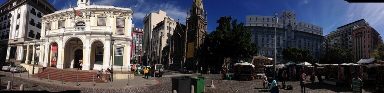 Historic white civic building beside a Cape Town street