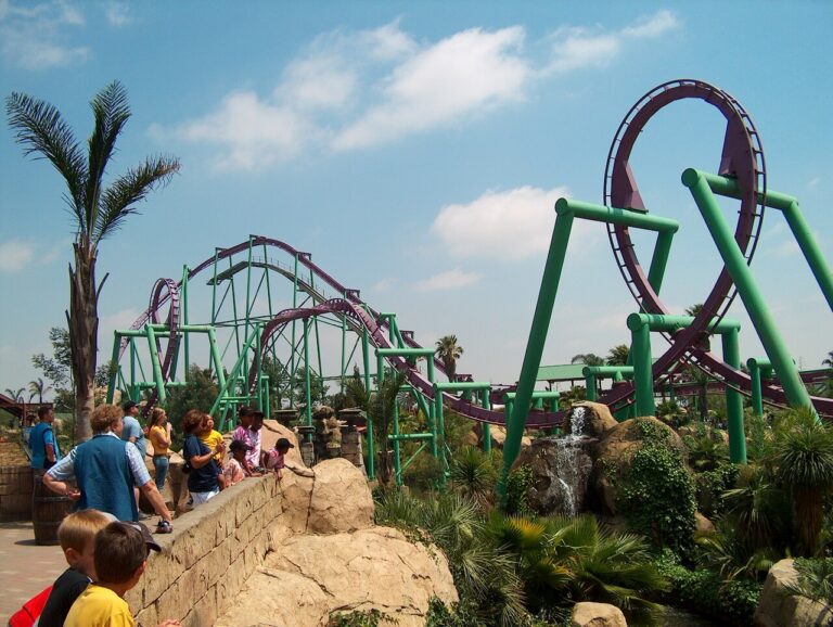Visitors beside a looping roller coaster at Gold Reef City