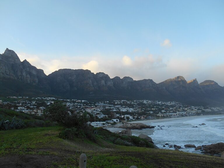 Coastal homes and a bay below a long mountain ridge