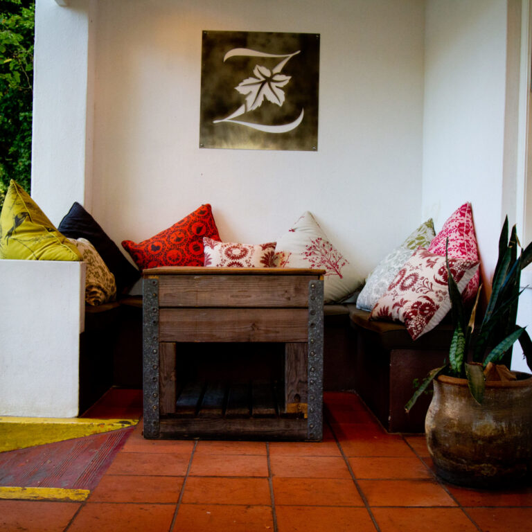 Cushioned seating around a wooden table inside a wine estate